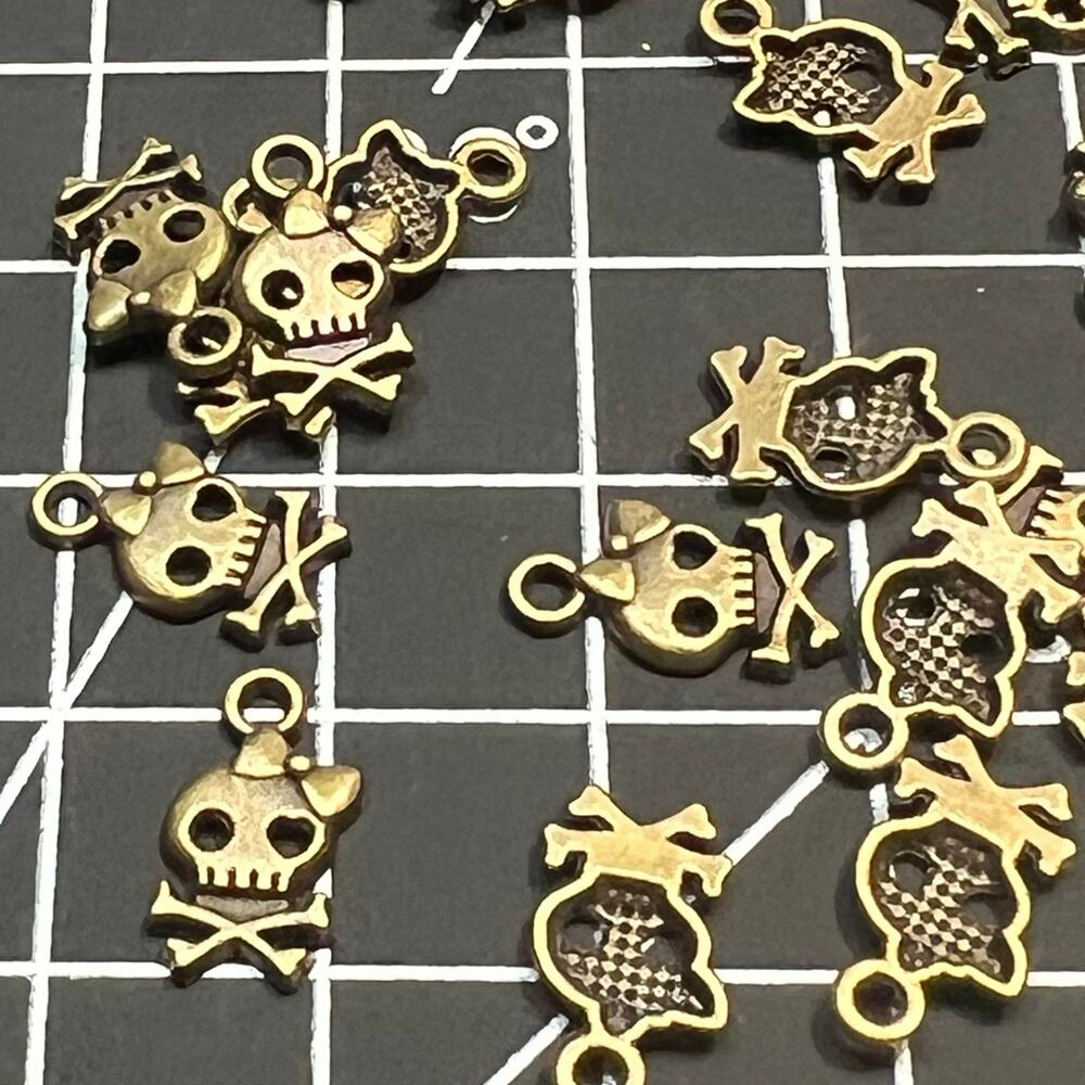 Lot of 70 bronze tone skull and cross bone with bow